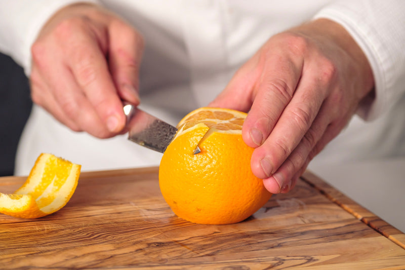 Allzweckmesser schält eine Orange